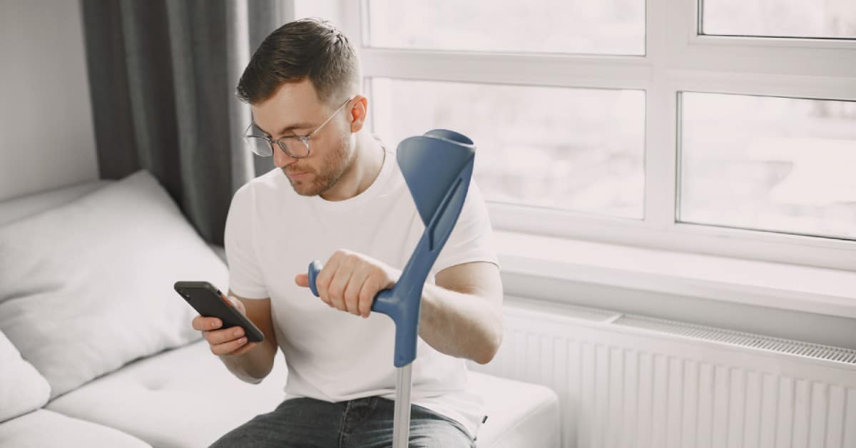 Patient mit einer Gehhilfe vereinbart Facharzttermin per Telefon